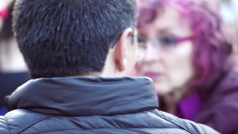 Un-Hombre-Con-Gafas-Habla-Con-Una-Mujer-De-Pelo-Morado-Y-Gafas-Durante-Una-Marcha-Y-Protesta