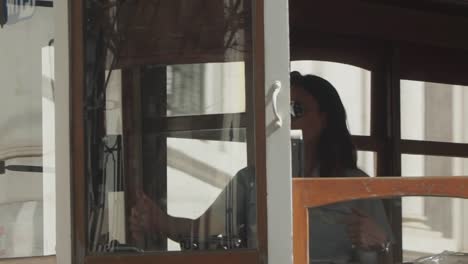 Close-up-shot,-Women-with-Glasses-driving-a-vintage-tram-in-Old-town,-Lisbon-Portugal