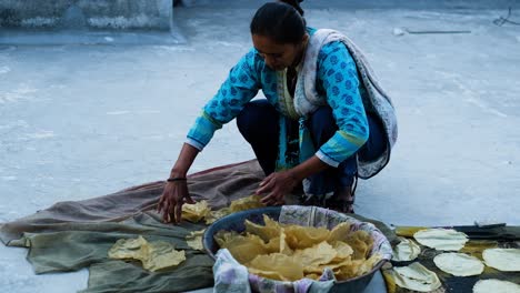 Mujer-India-Recogiendo-Papadam-Seco-En-Su-Cubo