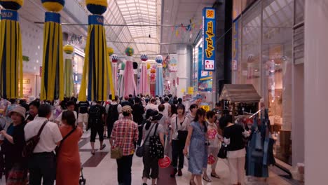 Gente-En-Arcade-Caminando-Entre-Serpentinas-De-Papel-Decorativas-Durante-El-Festival-De-Tanabata