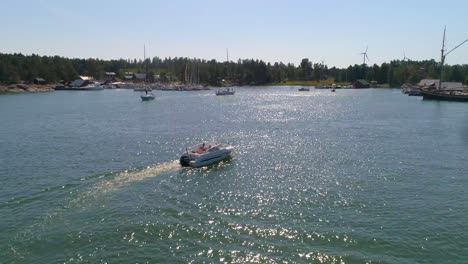 Luftaufnahme,-Verfolgung,-Drohnenaufnahme-Eines-Motorbootes,-Das-An-Einem-Sonnigen-Sommertag-In-Varsinais-Suomi,-Finnland,-In-Einem-Hafen-Auf-Der-Insel-Hogsara-Im-Finnischen-Archipel-Ankommt