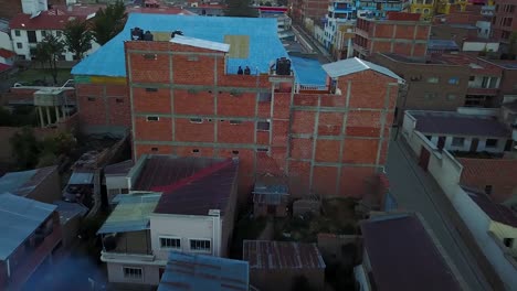 Aerial-drone-shot-away-from-people-on-a-building,-revealing-Copacabana-city,-in-Andes-mountains,-on-a-sunny-day,-on-the-shore-of-Lake-Titicaca,-in-Bolivia,-South-America