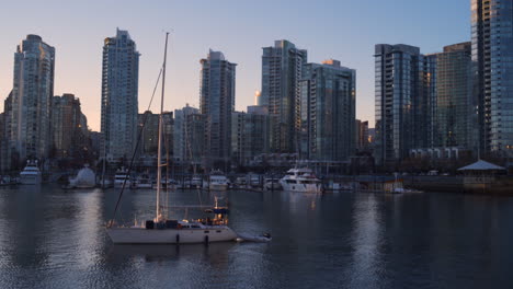 Una-Plataforma-Rodante-De-Derecha-A-Izquierda-Pasó-Junto-A-Un-Gran-Velero-Con-La-Puesta-De-Sol-Del-Centro-De-Vancouver-En-La-Distancia