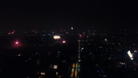 Ein-Sanfter-Und-ästhetisch-Ansprechender-Drohnenflug,-Der-An-Silvester-Ein-Atemberaubendes-Feuerwerk-Zeigt,-Das-Am-Horizont-Explodiert