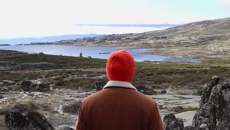 Hombre-Apreciando-El-Hermoso-Parque-Nacional-Serra-Da-Estrela-Desde-La-Cima-De-La-Montaña-Con-Vista-Al-Lago-Y-Luego-Caminando-Cuesta-Abajo