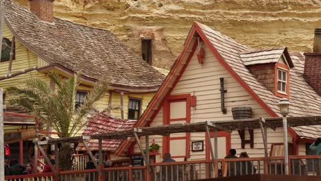 Tourists-Sitting-On-The-Benches-In-Popeye-Village,-Malta