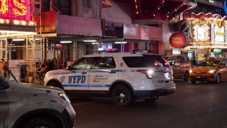 Una-Patrulla-De-La-Policía-De-Nueva-York-Gira-En-Times-Square-En-Nueva-York-Bajo-Todas-Las-Luces-Brillantes