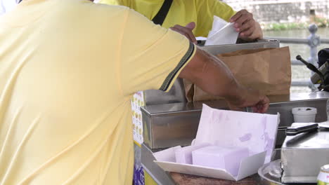 An-ice-cream-Peddlar-chopping-a-block-of-ice-cream-selling-waffle-sandwich-ice-cream-by-the-Singapore-river