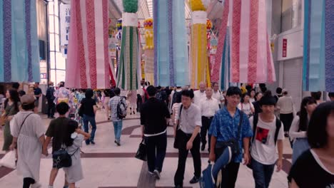 People-on-busy-street-walking-through-decorative-paper-streamers-during-Tanabata-festival-in-slow-motion