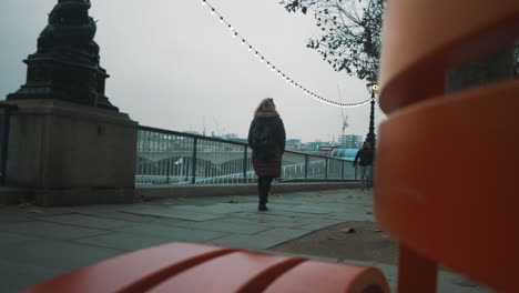 Slider-shot-people-walking-along-The-Queens-Walk-historic-promenade-near-the-River-Thames