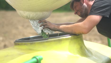 Farmer-packing-and-collecting-fresh-green-soy-beans-seeds-filling-up-a-huge-cistern,-during-the-soy-seeding-season-in-Brazil