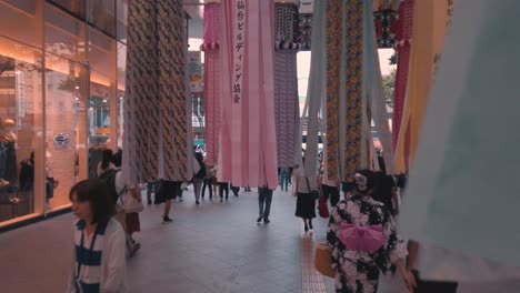 Menschen-Auf-Einer-Belebten-Straße,-Die-Während-Des-Tanabata-Festivals-In-Zeitlupe-Durch-Dekorative-Papierschlangen-Laufen