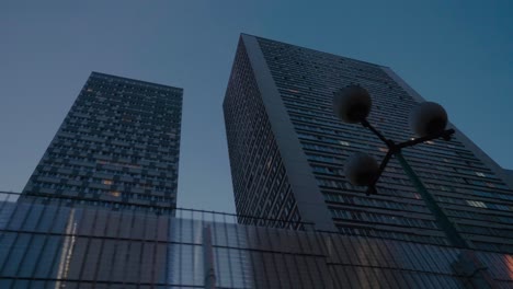 Moving-Past-Looking-Up-At-High-Rise-Tower-Apartments-In-Paris-Against-Blue-Skies