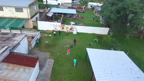 Niños-Jugando-En-Un-Barrio-Pobre,-Toma-Aérea-En-Cámara-Lenta