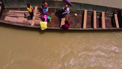 Gente-Descansando-En-Un-Barco-Anclado-En-Un-Río-Que-Fluye,-Agua-Sucia,-Huicungo,-Perú