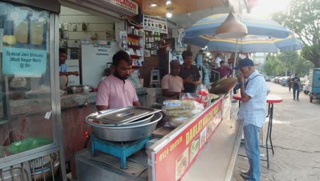 Cliente-Permanente-Comprando-Comida-Tradicional-India-En-Un-Puesto-En-Gurugram,-India