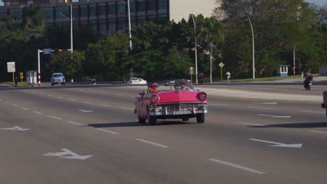 Handheld-tracking-shot-of-vintage-cars-in-Havana,-Cuba