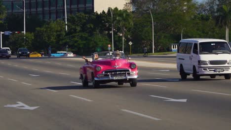 Handheld-tracking-shot-of-vintage-cars-in-Havana,-Cuba