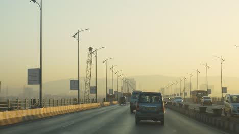 Driving-a-car-on-the-Mumbai-highway-towards-Panvel,-Lonavala,-Pune-at-beautiful-sunrise-with-beautiful-mountain-landscape-in-the-backdrop,-India