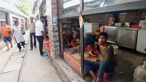 Dueño-De-Una-Tienda-India-Sosteniendo-Un-Pollo-O-Un-Gallo-En-El-Mercado,-Gurugram,-India