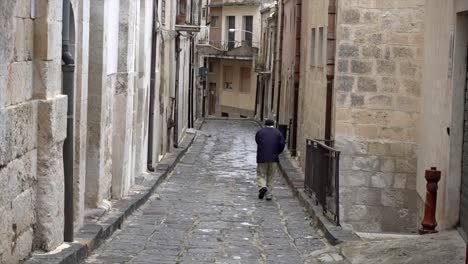 Un-Hombre-Caminando-Por-Una-Calle-Desolada-En-Mussomeli,-La-Ciudad-De-Sicilia-Donde-Se-Venden-Casas-A-1-Euro.