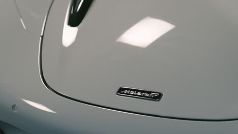 Logotipo-De-Mclaren-En-Un-Supercoche-Blanco-En-El-Estudio,-Reflejo-De-La-Luz,-Primer-Plano