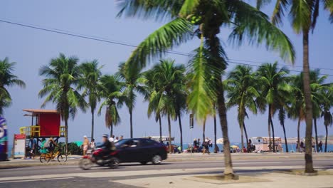 Cámara-Lenta-De-Tráfico-En-La-Carretera-Costera-Frente-A-Palmeras-Y-La-Playa-De-Ipanema-En-Río