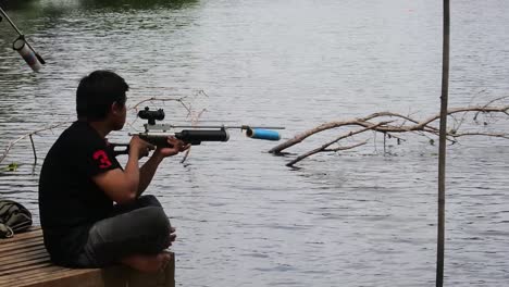 Un-Hombre-Busca-Peces-En-El-Borde-De-Un-Lago-Artificial-En-Depok,-Indonesia.