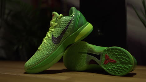 Green-Nike-Kobe-6-Protro-Grinch-2020-shoes-filmed-on-a-brown-table-with-dark-background