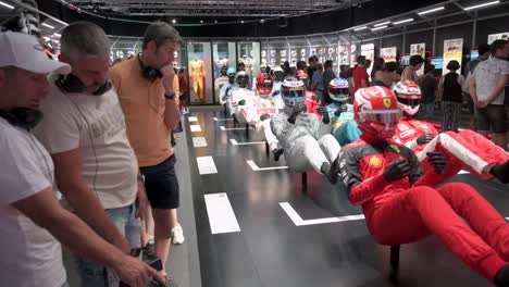 Los-Visitantes-Observan-Maniquíes-Vestidos-Con-Trajes-De-Carreras-Que-Destacan-La-Evolución-Del-Deporte-F1-Y-La-Seguridad-A-Través-Del-Tiempo-Durante-La-Primera-Exposición-Oficial-De-Fórmula-1-Del-Mundo.