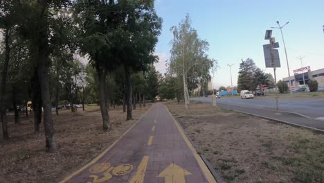 Disparo-De-Hiperlapso-Tomado-Desde-Una-Bicicleta-En-Un-Carril-Bici-De-Dos-Vías-En-La-Ciudad-De-Burgas,-Paralelo-A-Una-Autopista-Con-Mucho-Tráfico.