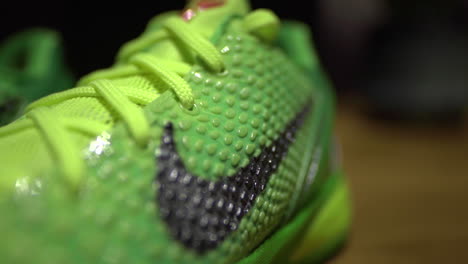 Zapatos-Nike-Kobe-6-Protro-Grinch-2020-Verdes-Filmados-Sobre-Una-Mesa-Marrón-Con-Fondo-Oscuro