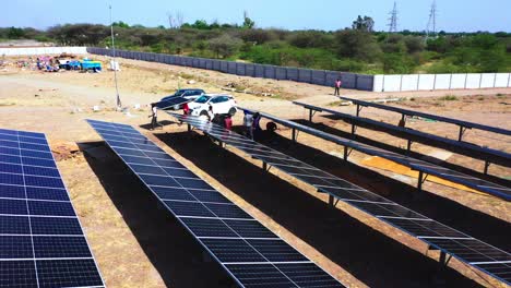 Vista-De-Cerca-De-La-Cámara-Aérea-De-Un-Dron-Donde-Los-Trabajadores-Recogen-Los-Módulos-Solares-Y-Los-Transportan-Para-Su-Instalación.