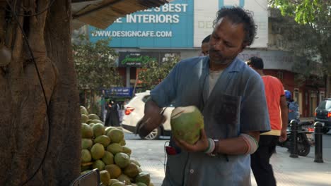 Vendedor-De-Coco-Tierno-Pelando-Cáscara-De-Coco-Con-Un-Cuchillo-Afilado-En-La-Calle