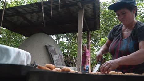 Close-Shot-Of-Woman-Using-Knife-Moving-Fresh-Bread