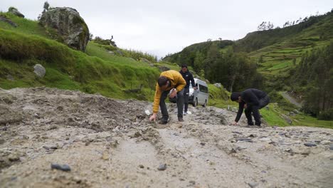 Hombres-Poniendo-Piedras-En-Un-Camino-De-Tierra-Seco-Con-Profundas-Huellas-De-Ruedas-Para-Hacerlo-Transitable-Para-El-Vehículo