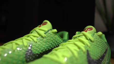 Green-Nike-Kobe-6-Protro-Grinch-2020-shoes-filmed-on-a-brown-table-with-dark-background