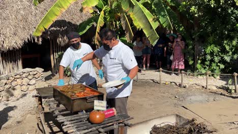 Toma-En-Cámara-Lenta-De-Chefs-Sirviendo-Una-Bandeja-De-Cochinita-Pibil-Al-Vapor