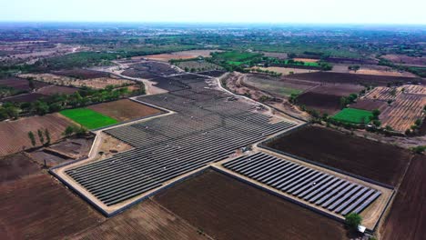 Die-Drohnenkamera-Aus-Der-Luft-Bewegt-Sich-Umher,-Um-Den-Gesamten-Solarpark-Zu-Sehen,-Der-Grüne-Energie-Erzeugt