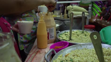 Mexican-chefs-serving-the-traditional-esquite-or-boiled-corn-at-a-street-stall