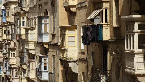 Balcones-Tradicionales-En-Una-Calle-Estrecha-Y-Montañosa-En-La-Valeta