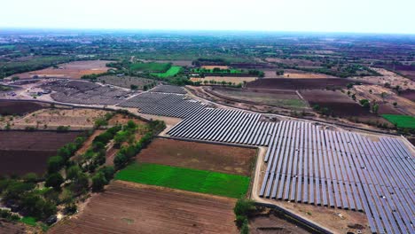 Cámara-Aérea-De-Drones-Que-Se-Mueve-Sobre-Una-Granja-Solar-Que-Genera-Energía-Verde-Y-La-Entrega-A-Una-Central-Eléctrica-Cercana.