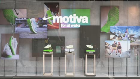 Los-Peatones-Pasan-Por-La-Multinacional-Estadounidense-Nike,-Marca-De-Ropa-Deportiva,-Tienda-Que-Muestra-Zapatos-A-La-Venta.