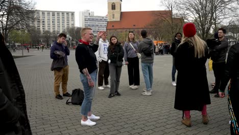 Guía-Turístico-Caminante-Hablando-Y-Explicando-Al-Grupo-Turístico-Sobre-Berlín-Junto-A-La-Fuente-De-Neptuno.