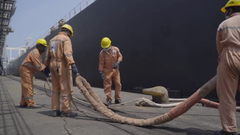 Hafenarbeiter-Entwirren-Die-Tross-Eines-Riesigen-Schiffes-Im-Hafen