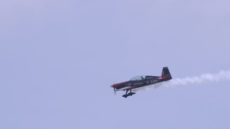 Primer-Plano-En-Cámara-Lenta-De-Un-Monoplano-Extra-De-300-Lp-Realizando-Acrobacias-Aéreas-Con-Humo-Blanco