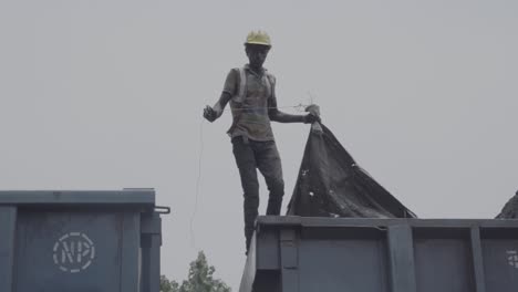 Trabajador-De-Una-Planta-De-Carbón-Con-Casco-De-Seguridad-Y-Chaleco-Que-Cubre-Mineral-De-Hierro-Cargado-En-Un-Vagón-De-Carga