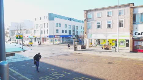 A-man-walking-in-Hemel-Hempstead-Town-Centre,-at-the-bus-interchange