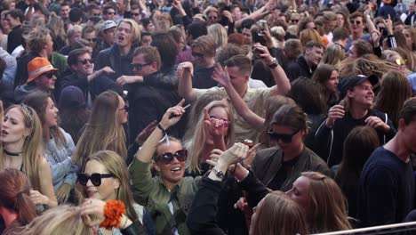 Young-festival-and-party-goers-enjoy-life-at-an-open-air-street-party-dancing-together-united-as-friends