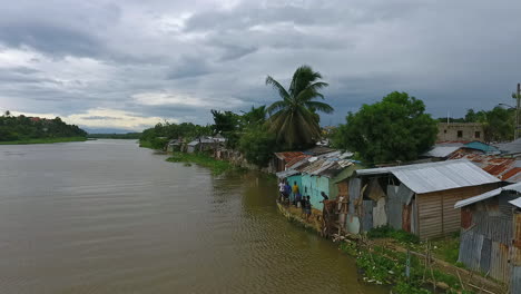 Disparo-Aéreo,-Drone-Alrededor-De-Personas,-Casas-Y-Hogares-En-La-Costa-Del-Río-Ozama,-En-Santo-Domingo,-República-Dominicana